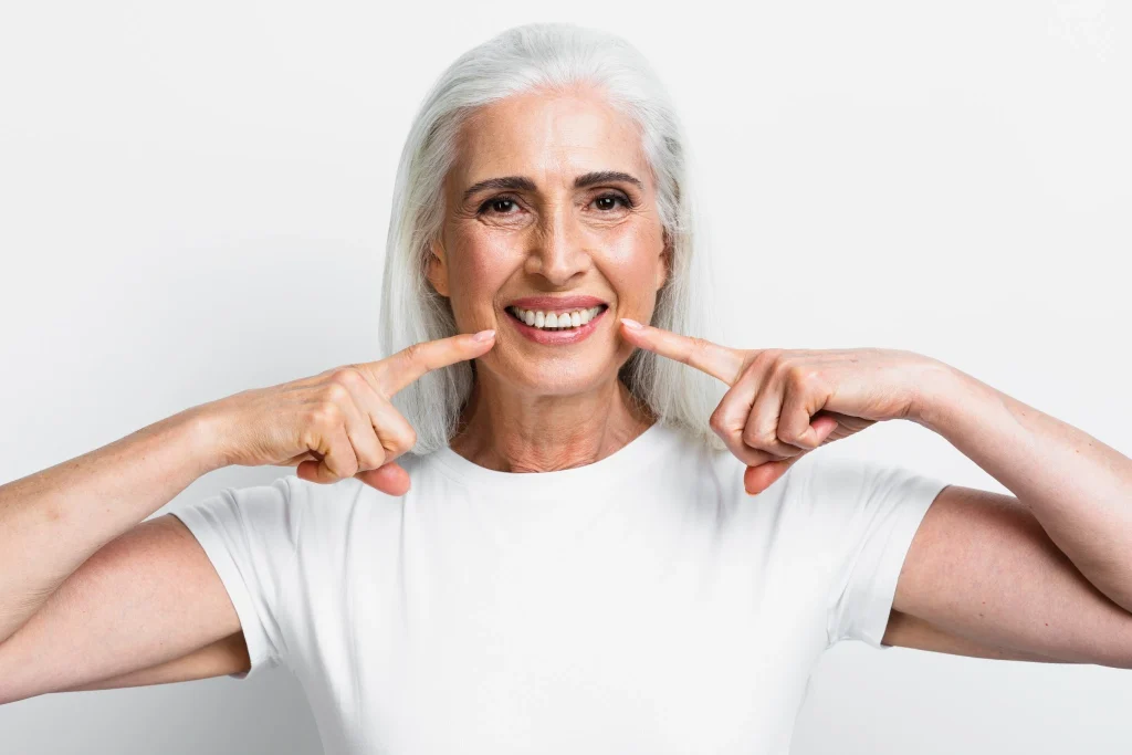 Smiling senior woman showing restored smile after full mouth dental implants