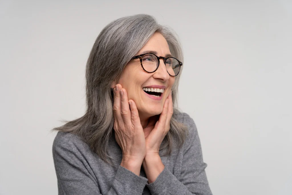 Happy senior woman smiling after single dental implant treatment